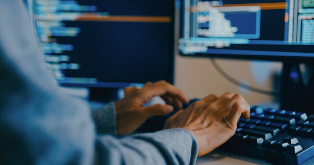 A close-up of a person’s hands typing on a keyboard