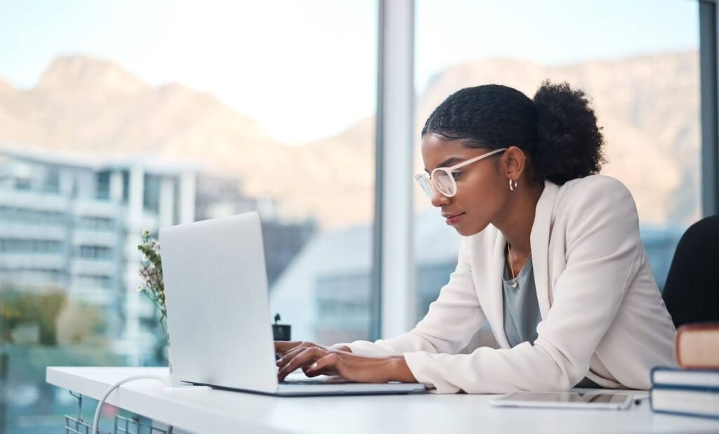 A female African outsourced email support specialist working in an office