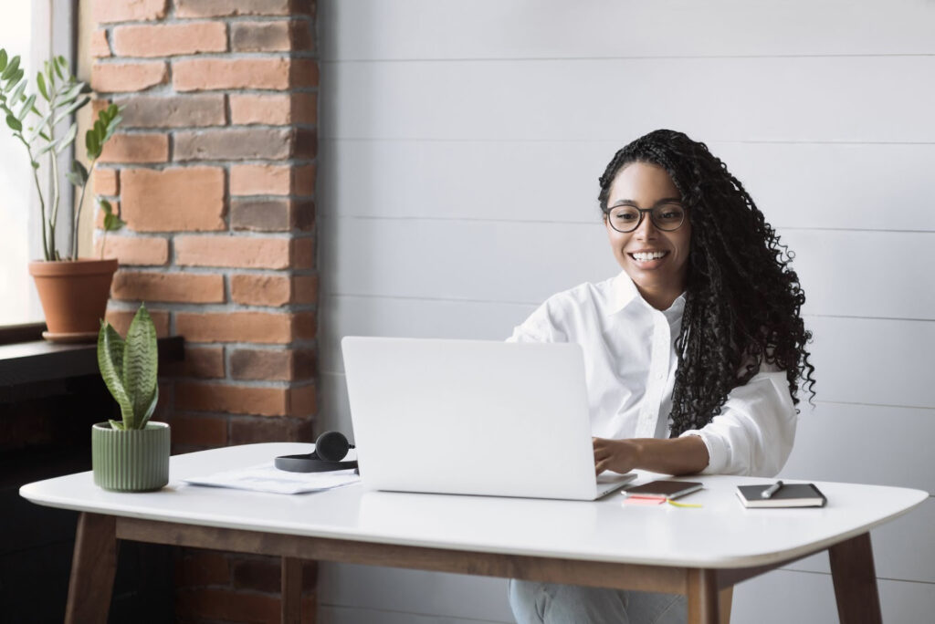 A smiling African businesswoman working on her laptop