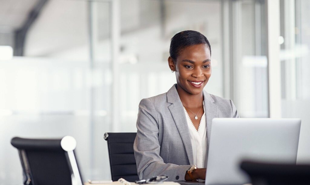 African woman working on insurance claims on her laptop