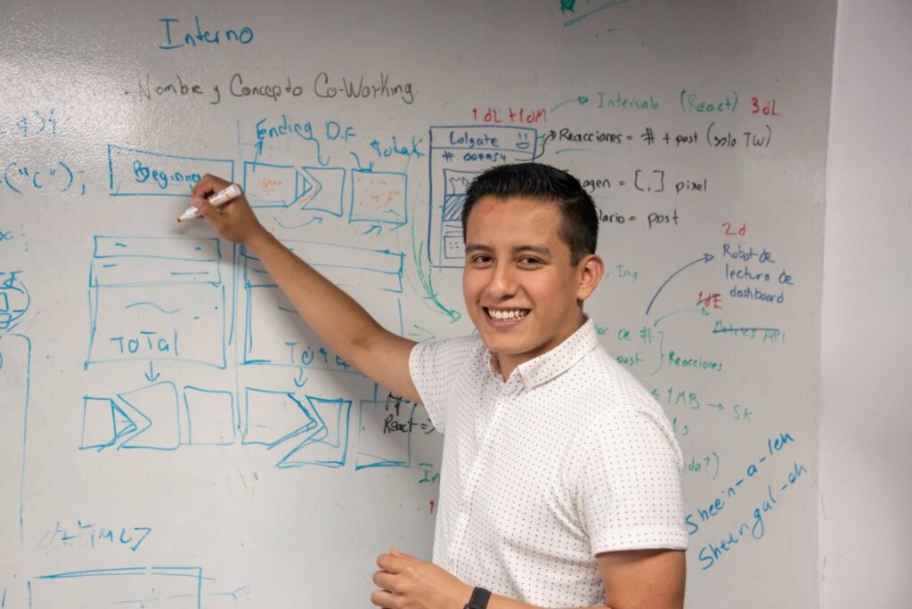 An outsourced male professional from the Dominican Republic writing on a whiteboard