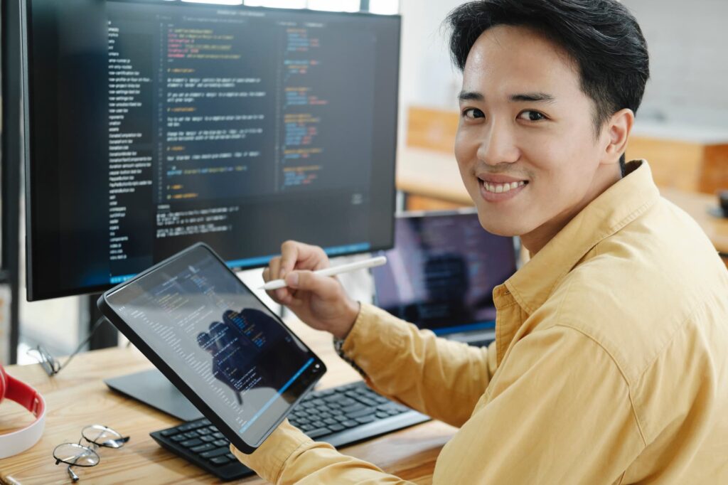 Programmer smiling while working — Top BPO Solutions | Outsourcing Services In The Philippines