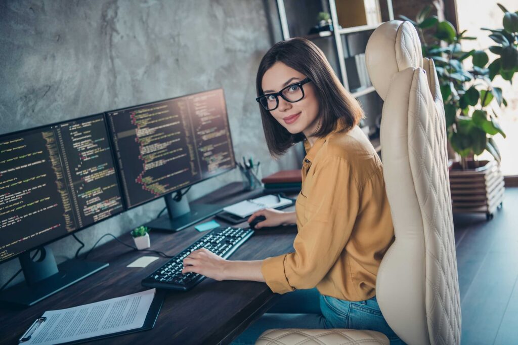 Developer in front of two screens — Top BPO Solutions | Outsourcing Services In The Philippines