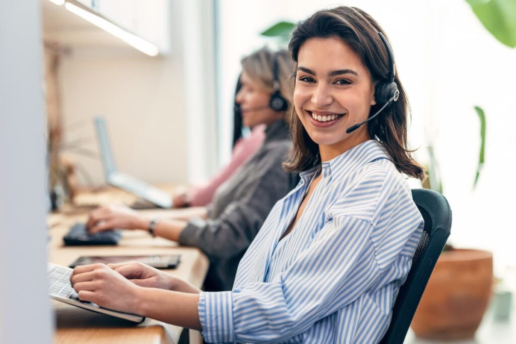 Woman agent wearing headset smiling — Business process outsourcing & offshore staffing | Sourcefit