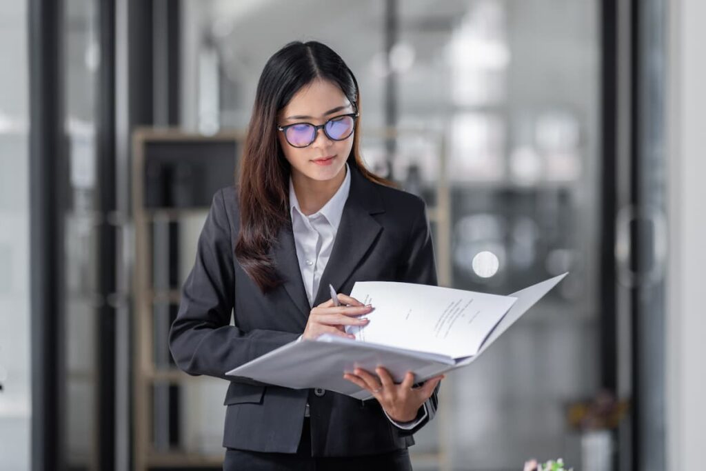 Lady wearing glasses reading a document — Business process outsourcing & offshore staffing | Sourcefit