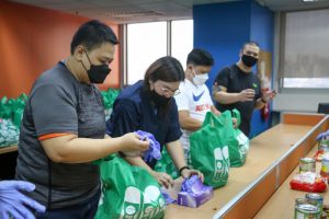 employees wearing masks packing food donations