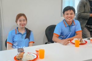 woman and man smiling with food on their table
